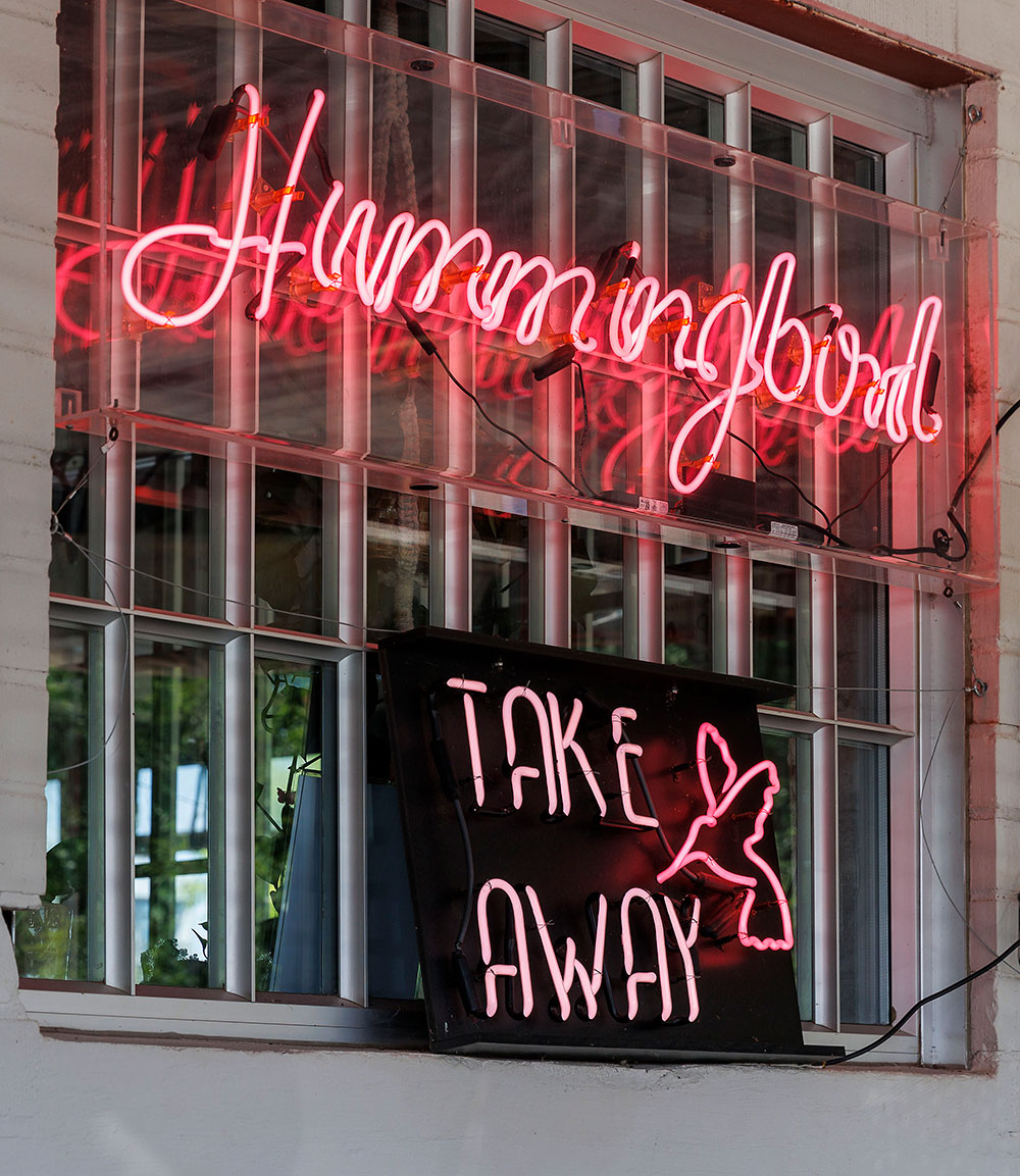 The neon lights of Hummingbird invite people in from its beloved patio.