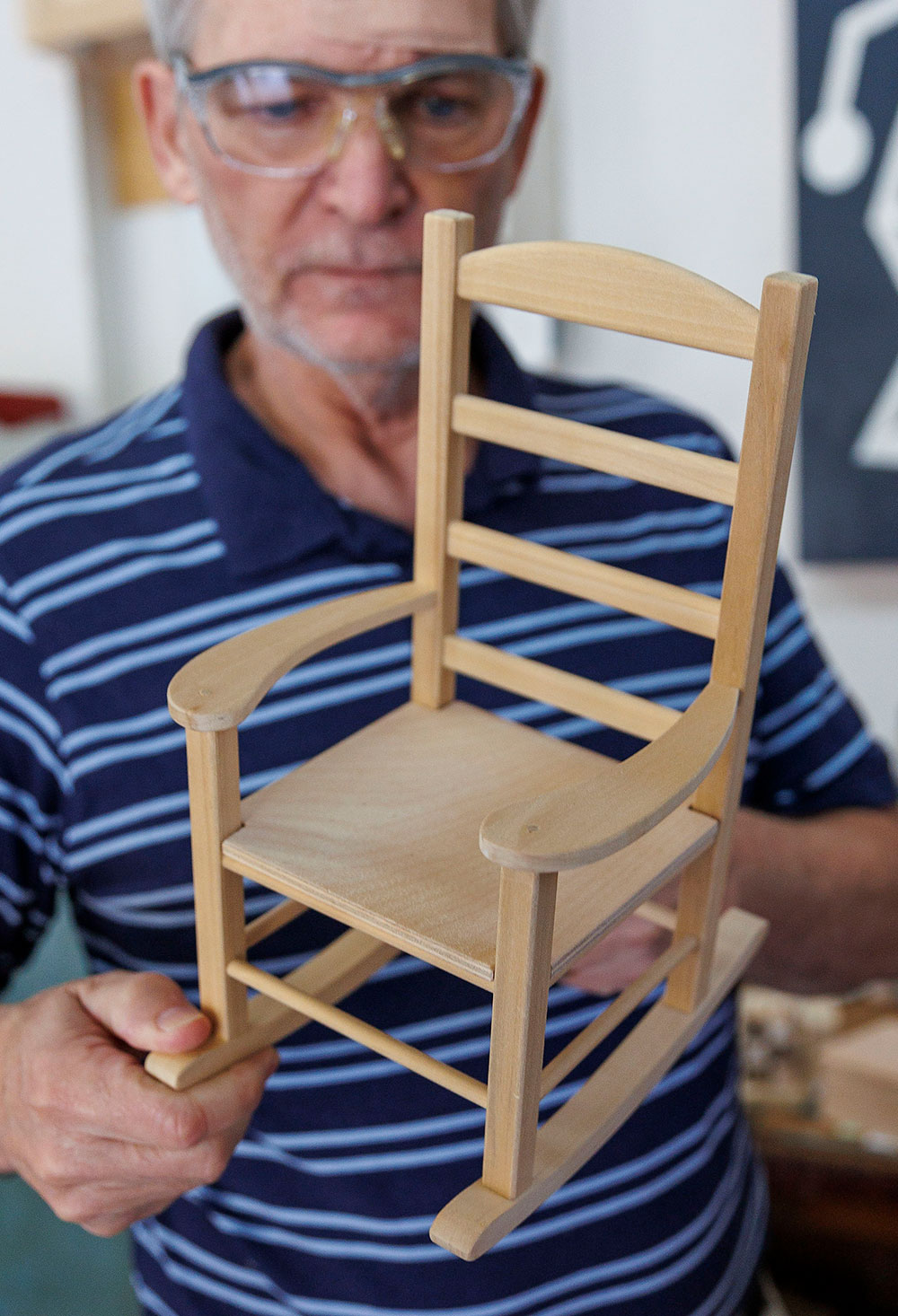TWA President Roy Brookhart shows off one of his favorite creations: an American Girl-sized rocking chair.