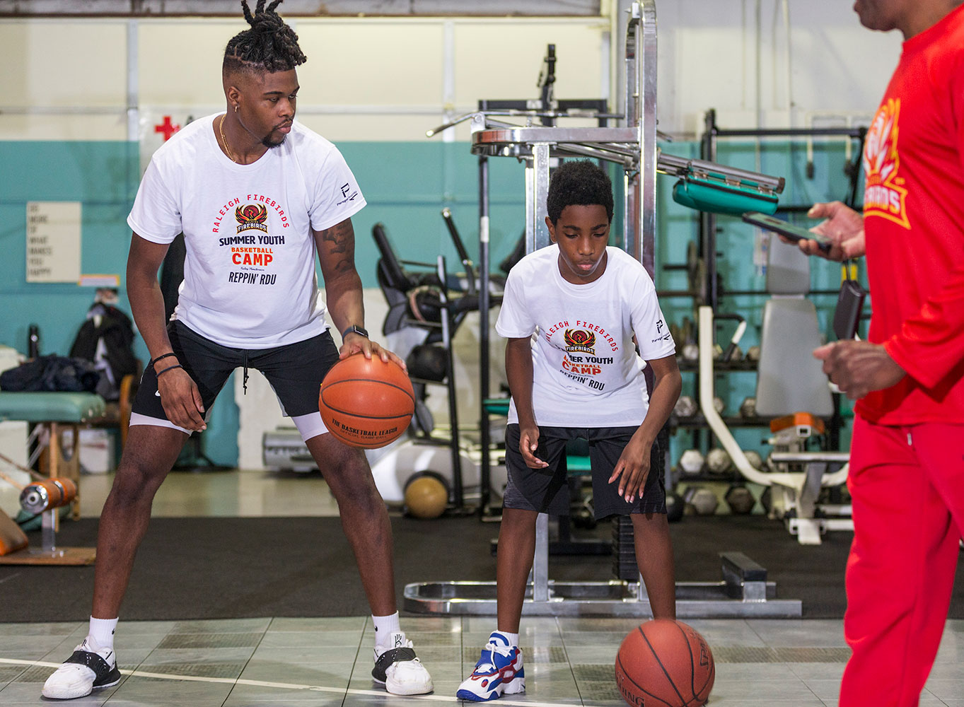 Jody Dozier, 13, takes a few lessons in dribbling from Jamel McAllister, a former Firebirds player who now plays in a professional league in Germany.