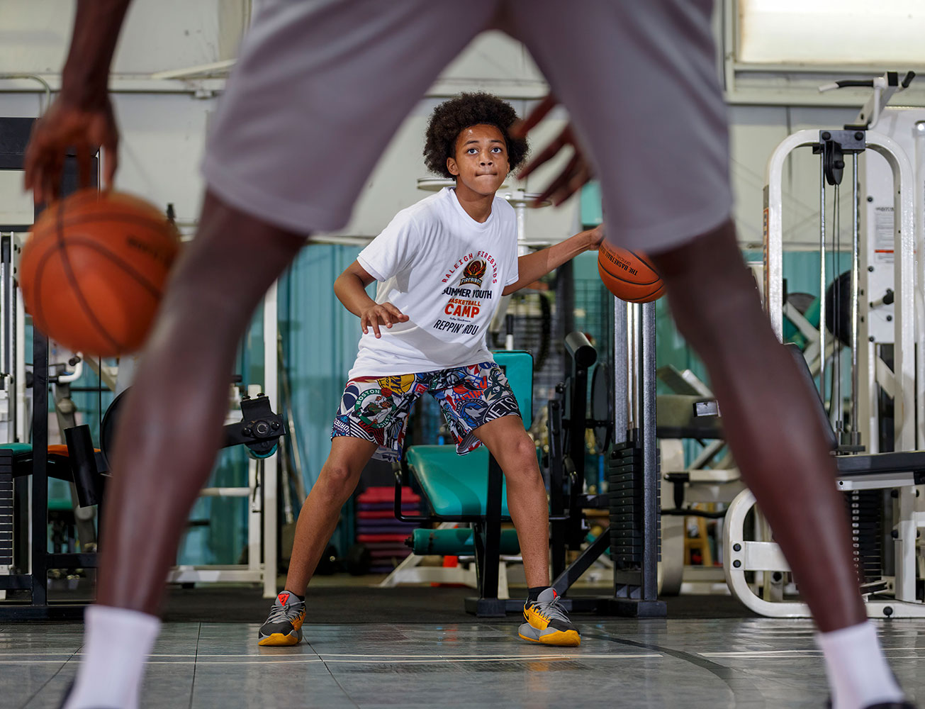 Giovanni Lovington, 12, practices dribbling in front of 7-foottall Khadim Gueye.